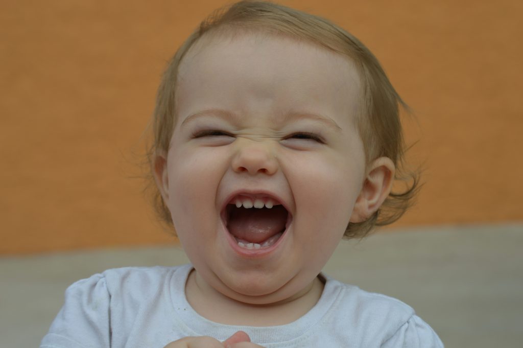 baby girl showing her teeth